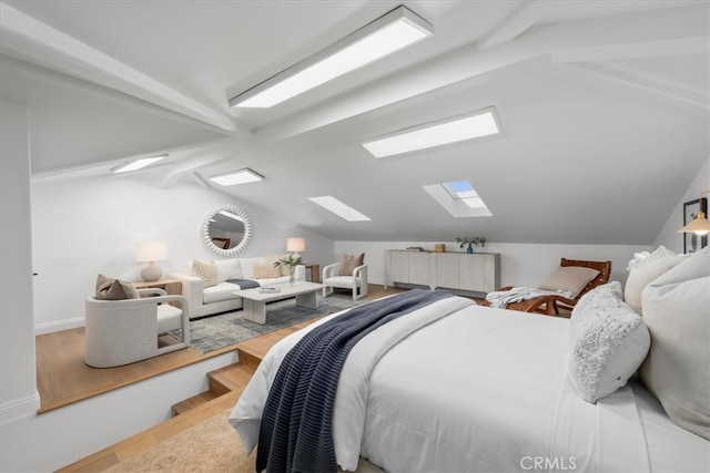 bedroom featuring light hardwood / wood-style floors and vaulted ceiling with skylight