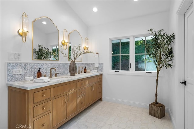 bathroom featuring vanity, lofted ceiling, and backsplash