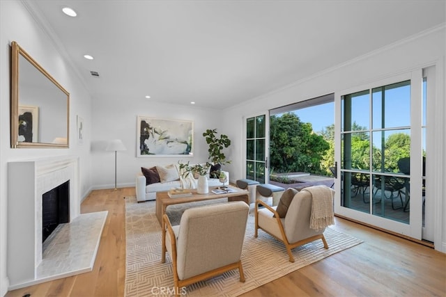 living room with light hardwood / wood-style floors and crown molding