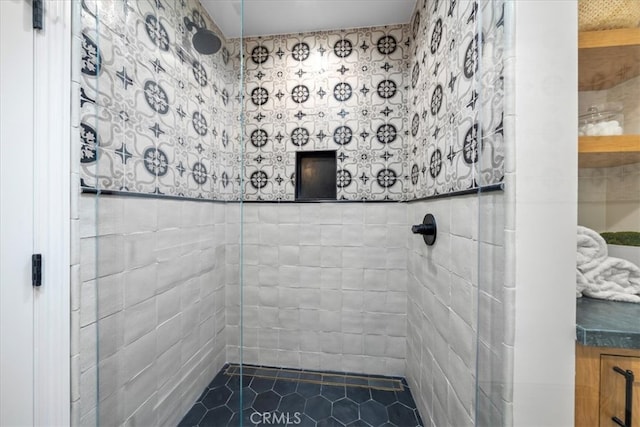 bathroom featuring a tile shower and tile patterned flooring