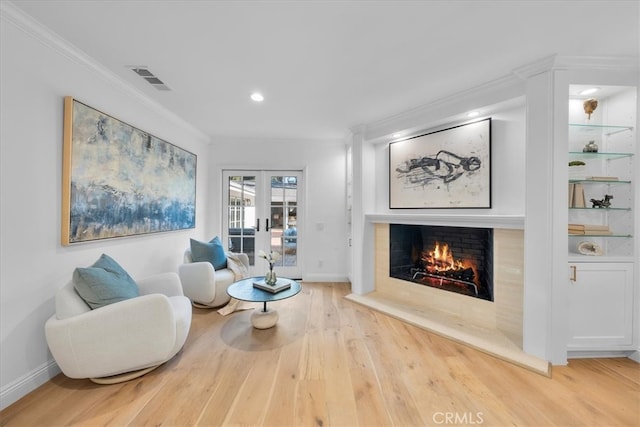 living room with french doors, ornamental molding, and hardwood / wood-style floors