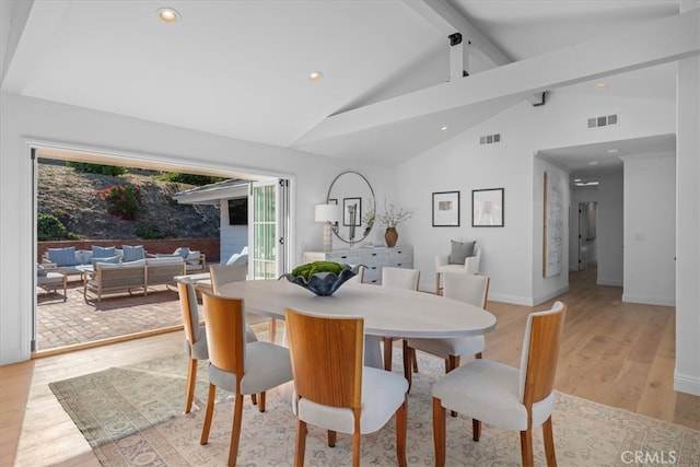 dining space with beamed ceiling, high vaulted ceiling, and light wood-type flooring