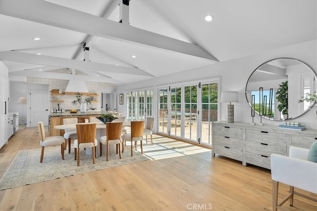 dining room featuring light hardwood / wood-style floors and lofted ceiling with beams