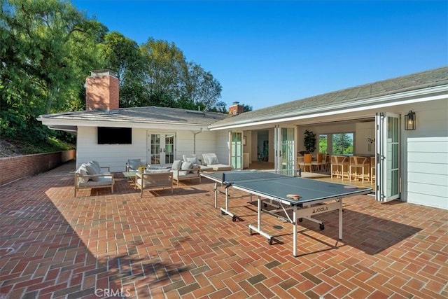 back of property featuring french doors, a patio area, and an outdoor hangout area