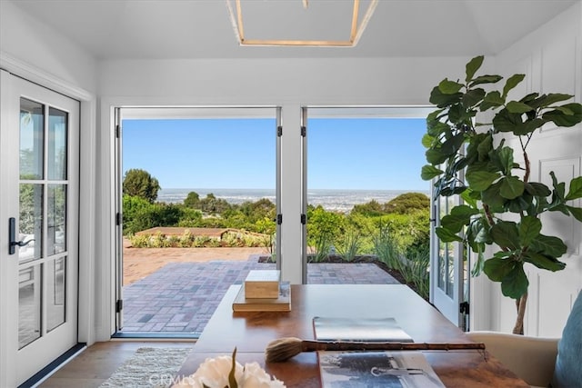 doorway to outside with light hardwood / wood-style floors and a water view