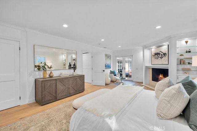 bedroom with french doors, ornamental molding, and light hardwood / wood-style flooring