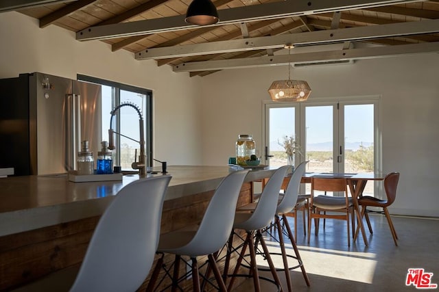 dining space featuring vaulted ceiling with beams, wood ceiling, and a healthy amount of sunlight