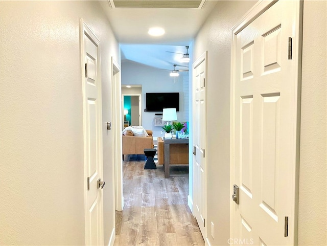 hall featuring vaulted ceiling and light hardwood / wood-style floors