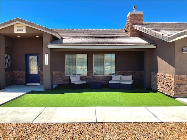 property entrance featuring an outdoor living space, stucco siding, a tile roof, and stone siding