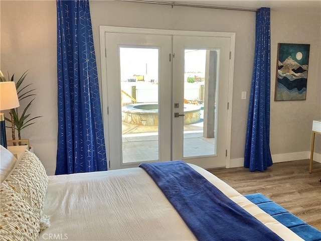 bedroom featuring wood finished floors, french doors, and baseboards