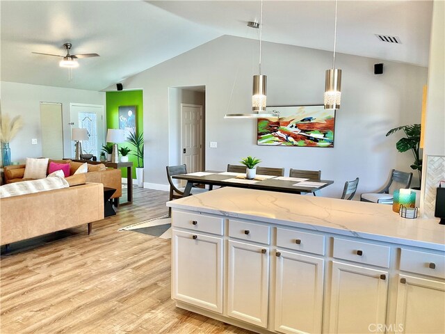 kitchen featuring ceiling fan, pendant lighting, light stone counters, light hardwood / wood-style flooring, and white cabinetry