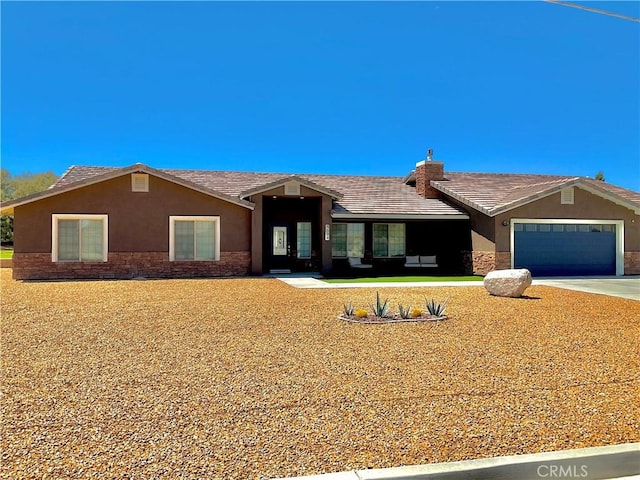 ranch-style home with stone siding, stucco siding, concrete driveway, and an attached garage