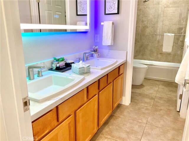 full bathroom with vanity, tiled shower / bath combo, toilet, and tile patterned floors