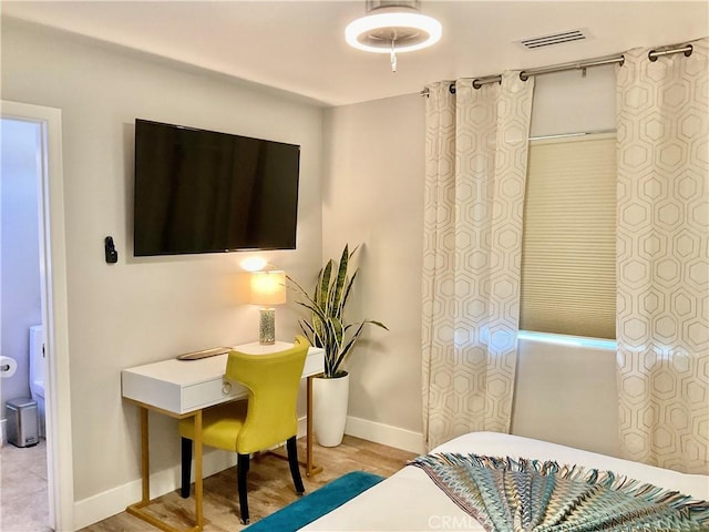 bedroom with visible vents, light wood-style floors, and baseboards