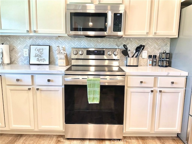 kitchen with backsplash, stainless steel appliances, and light countertops
