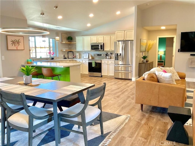 kitchen with decorative backsplash, appliances with stainless steel finishes, light countertops, white cabinets, and lofted ceiling