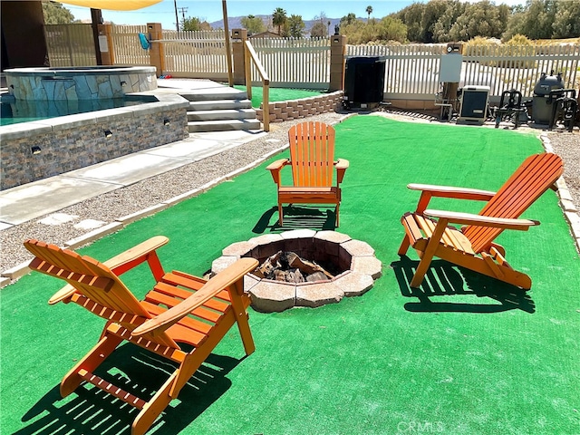 surrounding community featuring a patio area, a hot tub, and an outdoor fire pit