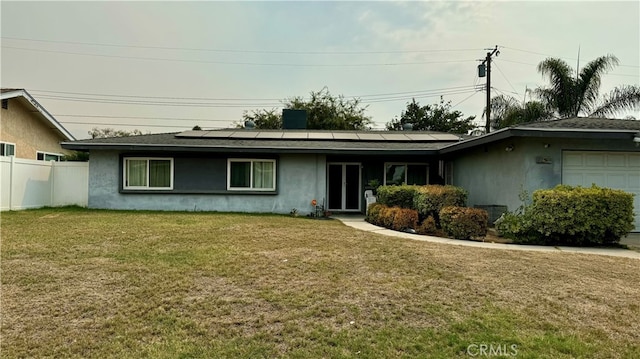 exterior space with a garage, a lawn, and solar panels