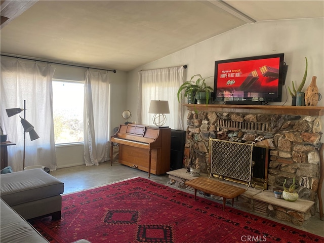 living room with vaulted ceiling with beams and a stone fireplace