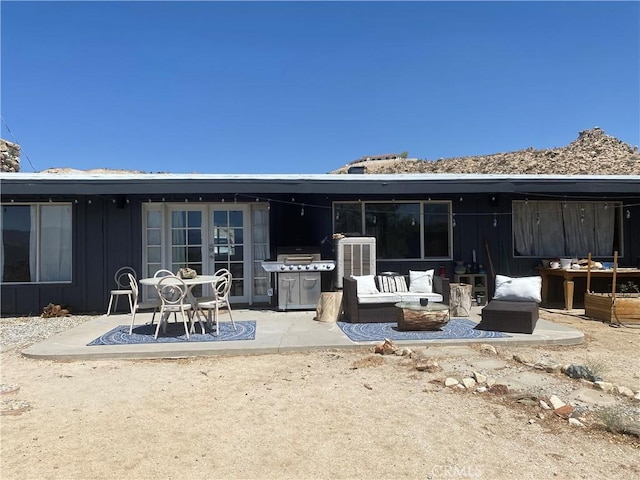 6161 Mirlo Rd, Yucca Valley, CA 92284 - back of property featuring an outdoor living space, board and batten siding, a patio area, and central AC