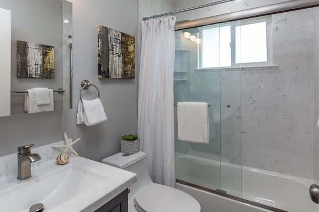 full bathroom featuring shower / bath combination with curtain, vanity, and toilet