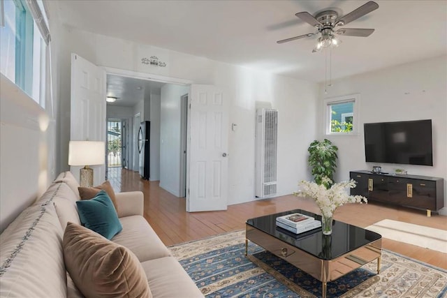 living room with wood-type flooring, a healthy amount of sunlight, and ceiling fan