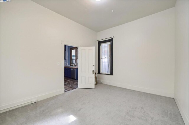 spare room with lofted ceiling and carpet