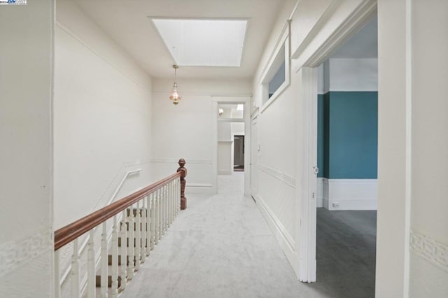 hall with light carpet and a skylight