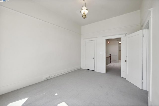 unfurnished bedroom featuring light colored carpet and a closet