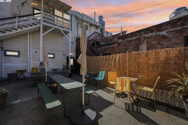 patio terrace at dusk featuring a balcony