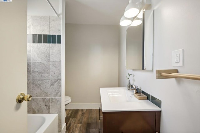 full bathroom with tiled shower / bath combo, vanity, toilet, and hardwood / wood-style flooring