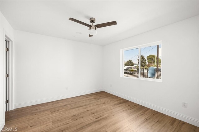 empty room with ceiling fan and hardwood / wood-style flooring