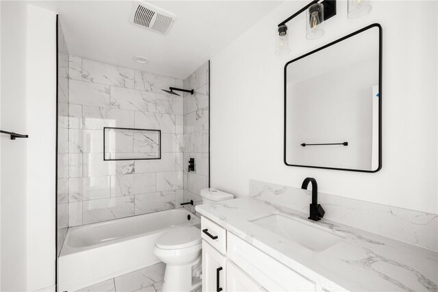 full bathroom featuring vanity, tiled shower / bath combo, and toilet