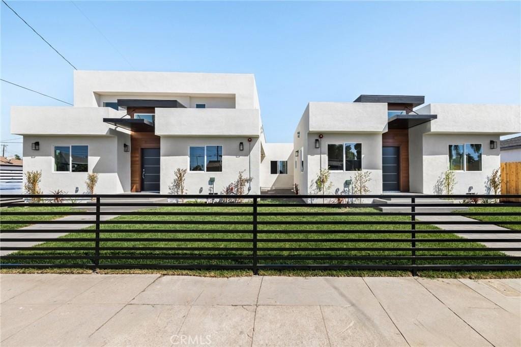 947 W Magnolia St, Compton, CA 90220 - view of front of home with a fenced front yard, a front yard, and stucco siding