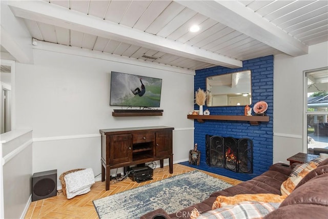 living room featuring a fireplace, beamed ceiling, and parquet floors