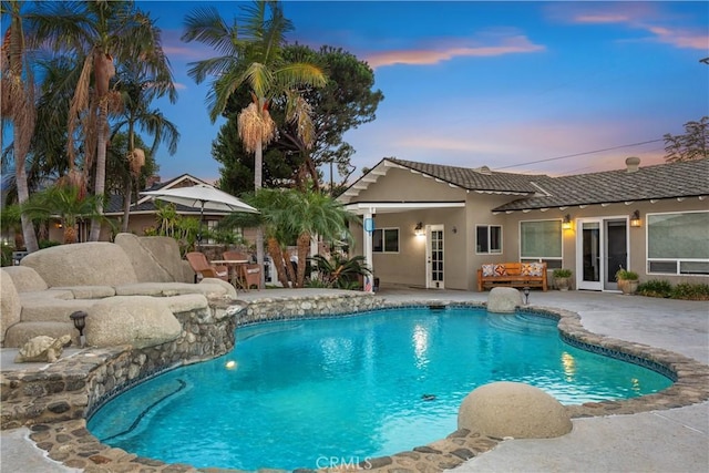 pool at dusk with a patio