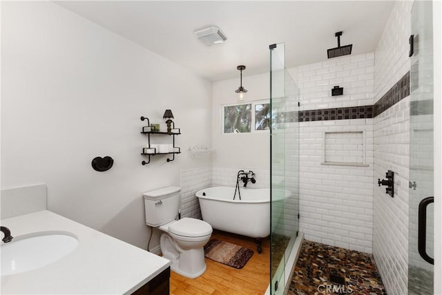 full bathroom featuring plus walk in shower, wood-type flooring, vanity, and toilet