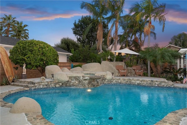 pool at dusk with a patio