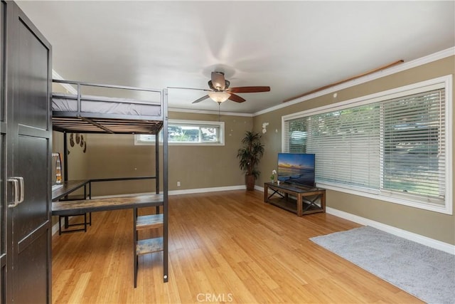 bedroom with ceiling fan, light hardwood / wood-style floors, and ornamental molding