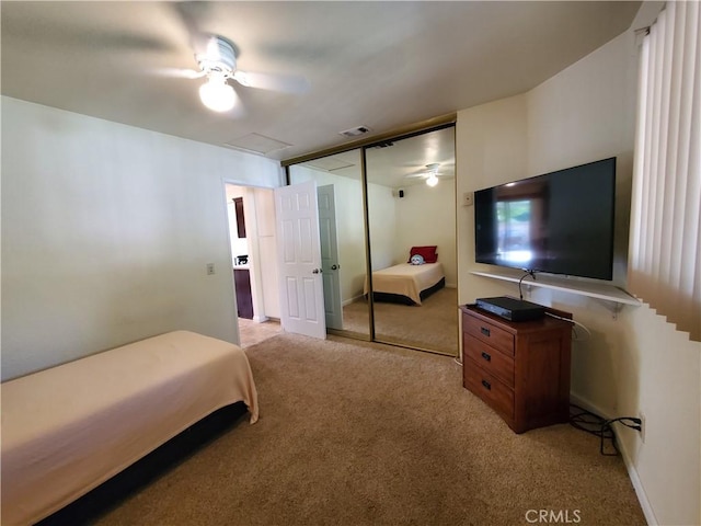 bedroom featuring ceiling fan, light colored carpet, and a closet