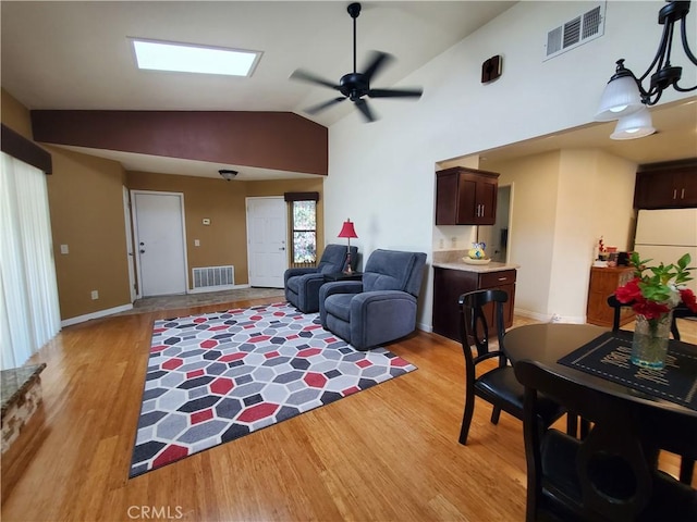 living room with ceiling fan, light hardwood / wood-style floors, and lofted ceiling