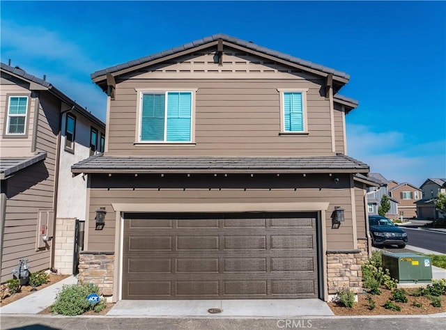 15032 Gallery Way Unit 8, Fontana, CA 92336 - view of front of house featuring stone siding, an attached garage, and concrete driveway