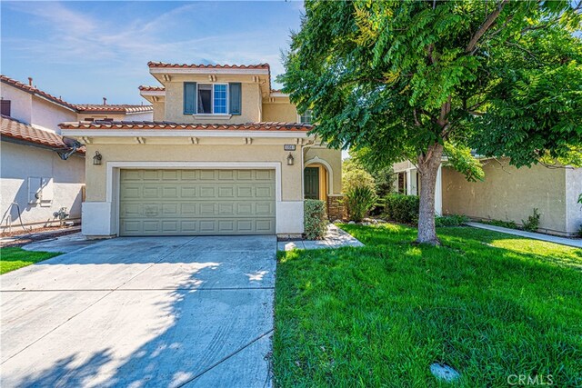 mediterranean / spanish home with a front lawn and a garage