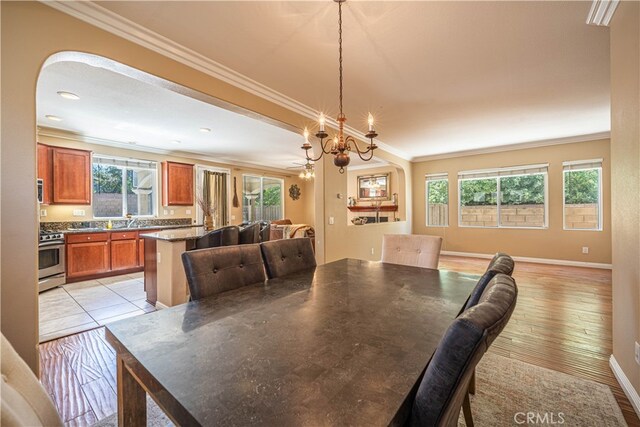 dining area with light wood-type flooring, crown molding, plenty of natural light, and sink