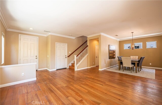 dining space with ornamental molding, hardwood / wood-style floors, and a chandelier