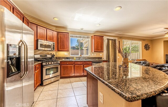 kitchen with plenty of natural light, crown molding, appliances with stainless steel finishes, and a center island