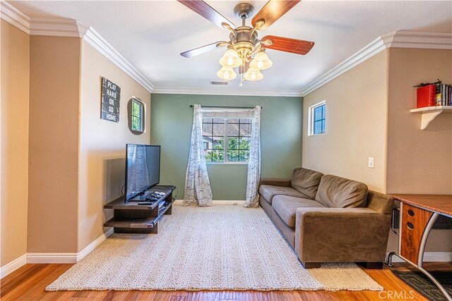 living room featuring ceiling fan, hardwood / wood-style flooring, and ornamental molding