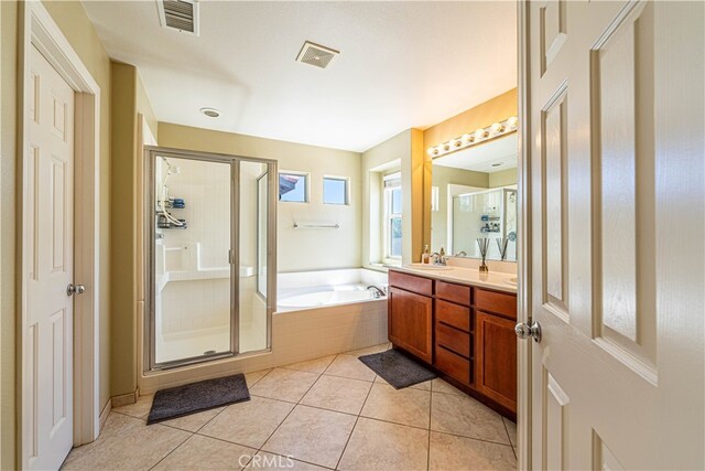 bathroom featuring tile patterned flooring, plus walk in shower, and vanity