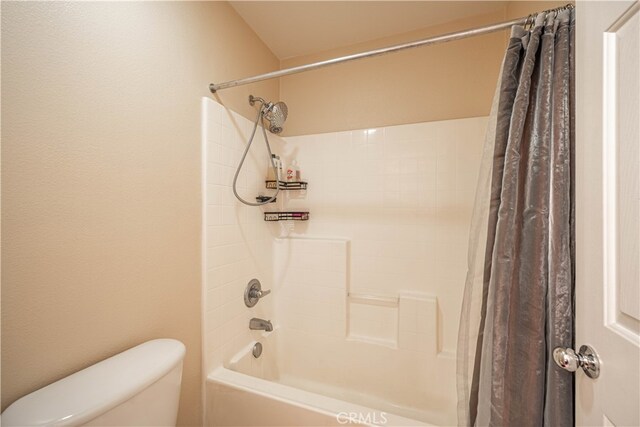 bathroom featuring shower / bath combination with curtain and toilet