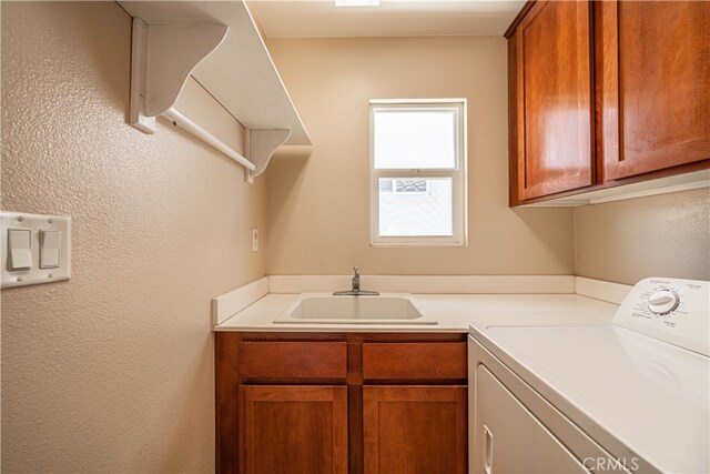 clothes washing area featuring sink, cabinets, and washer / dryer